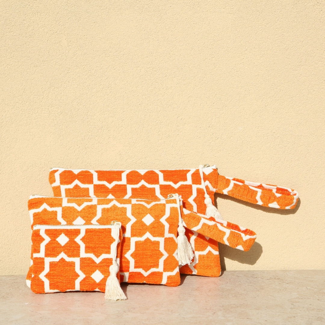 Marabu star clutch in orange — bold geometric star print on natural cotton canvas, tassel zip, handmade in Greece