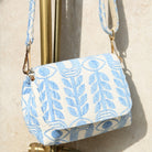 Marabu crossbody bag detail — light blue Unity print cotton with gold clasp and adjustable printed strap, made in Greece