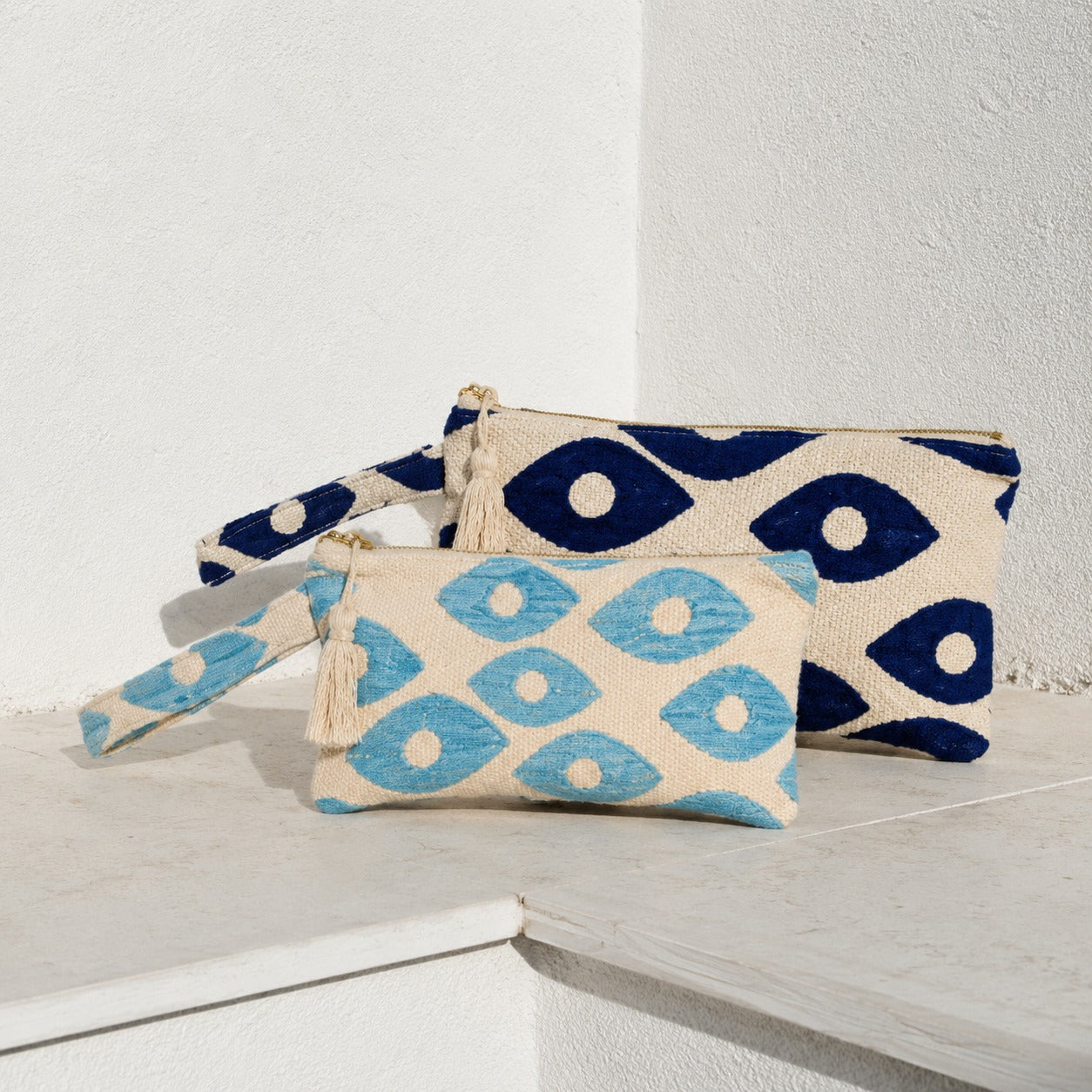 Marabu fish eye clutch in deep blue and turquoise — bold fish eye motif on natural cotton, tassel zip, handmade in Greece