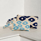 Marabu fish eye clutch in deep blue and turquoise — bold fish eye motif on natural cotton, tassel zip, handmade in Greece