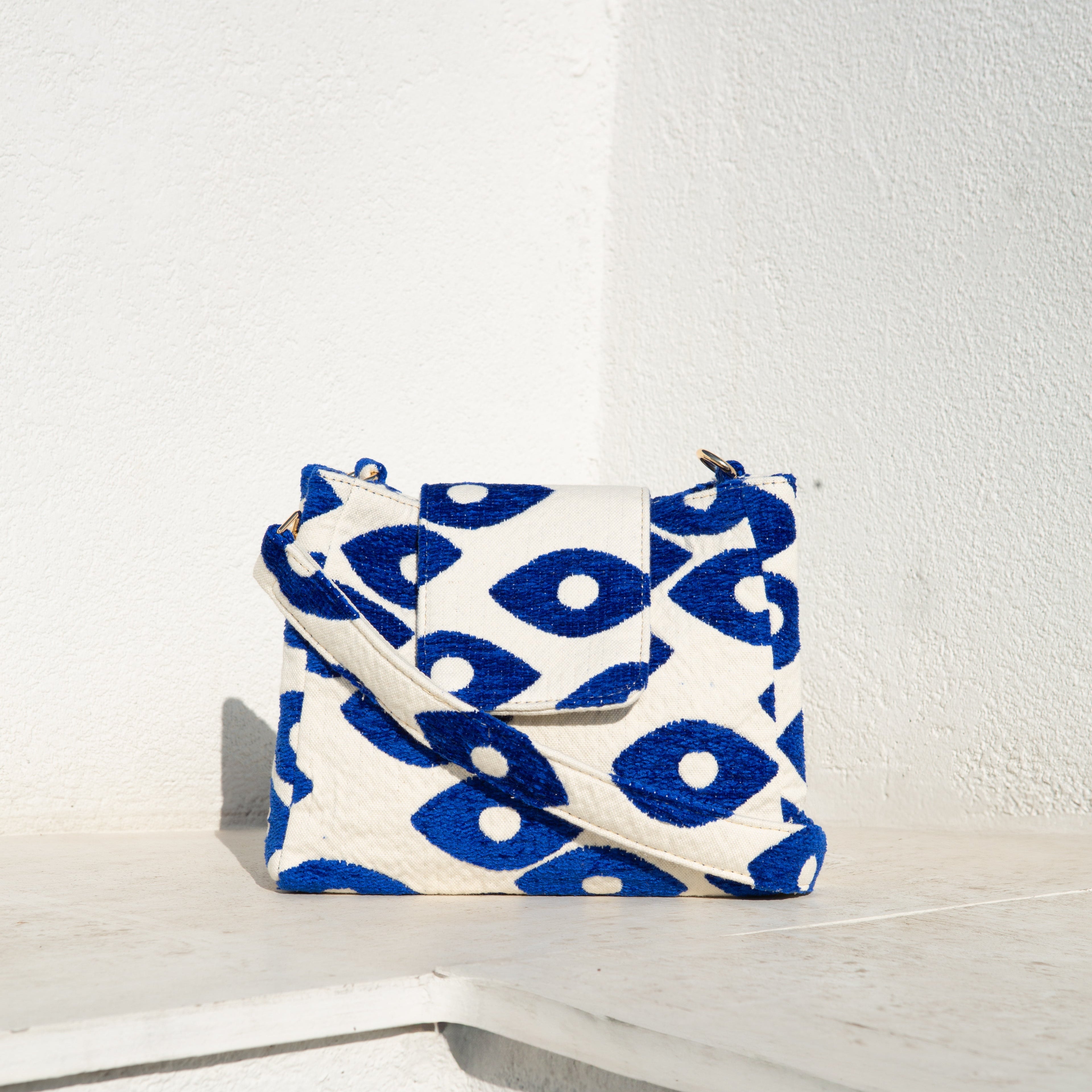 Marabu flap bag in deep blue Fish Eye print — structured cotton with adjustable strap and gold hardware, made in Greece
