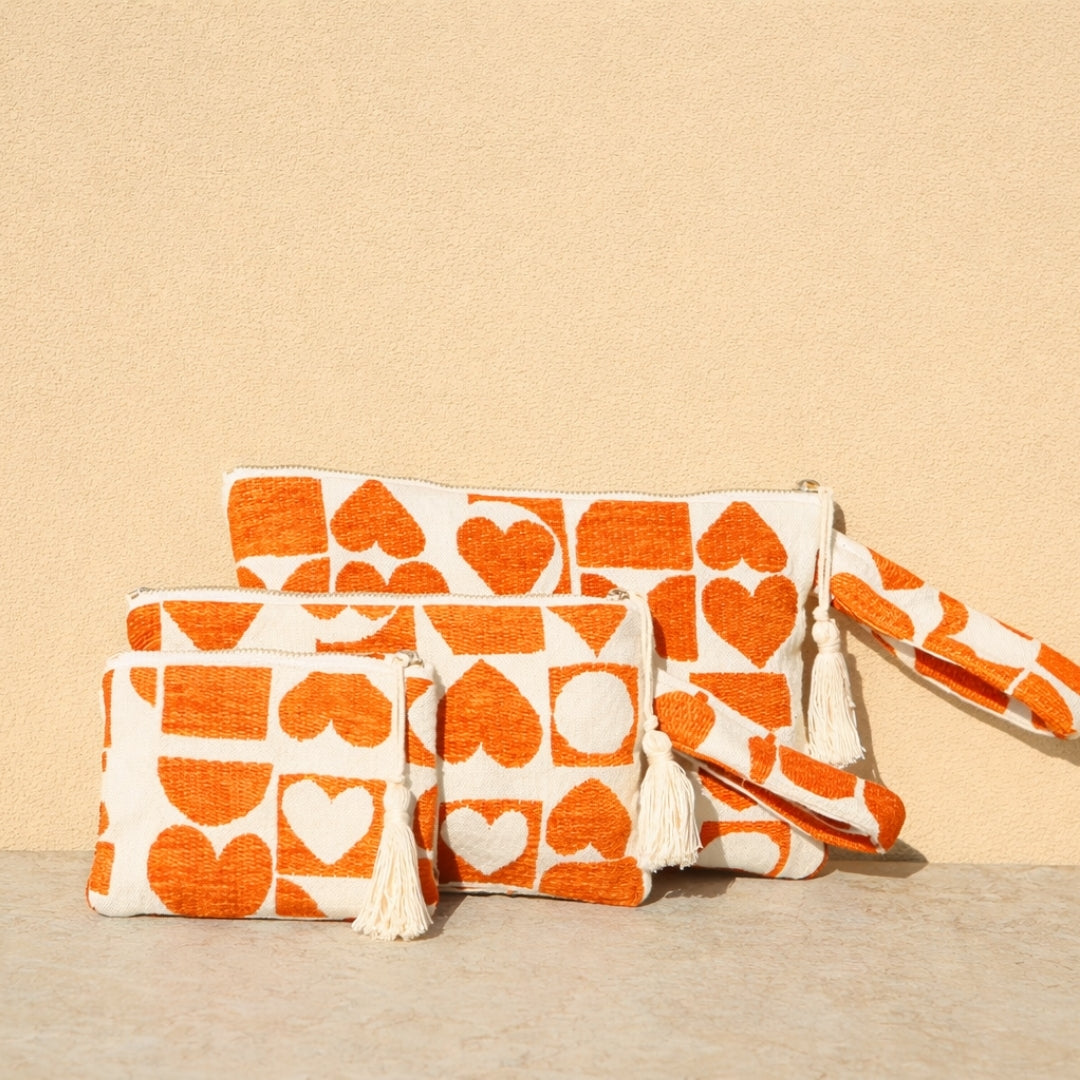Marabu heart clutch in orange — bold heart print on natural cotton canvas, tassel zip, handmade in Greece