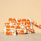 Marabu heart clutch in orange — bold heart print on natural cotton canvas, tassel zip, handmade in Greece