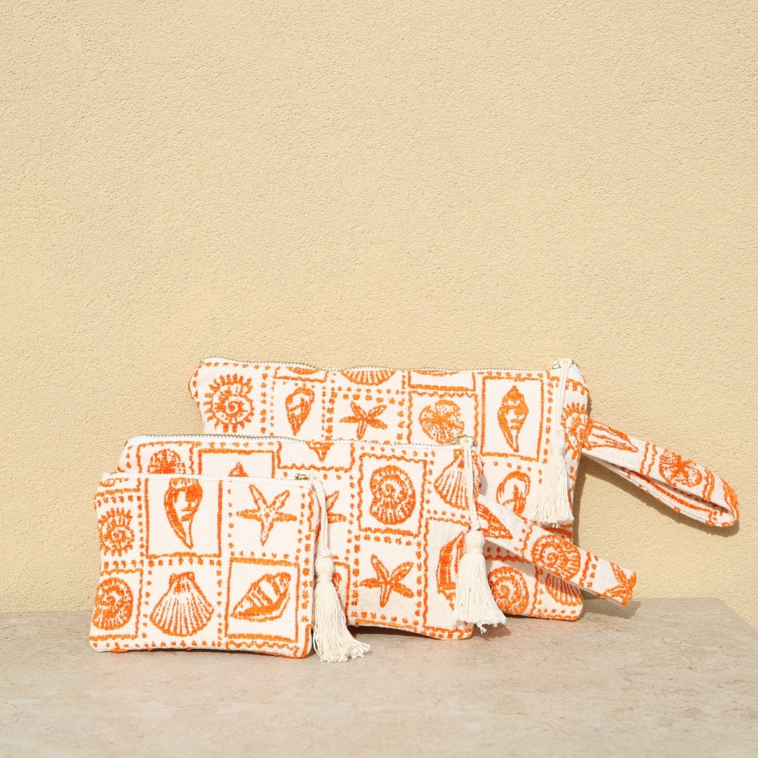 Marabu seashell clutch in orange — bold coastal print with shells and starfish, natural cotton, handmade in Greece