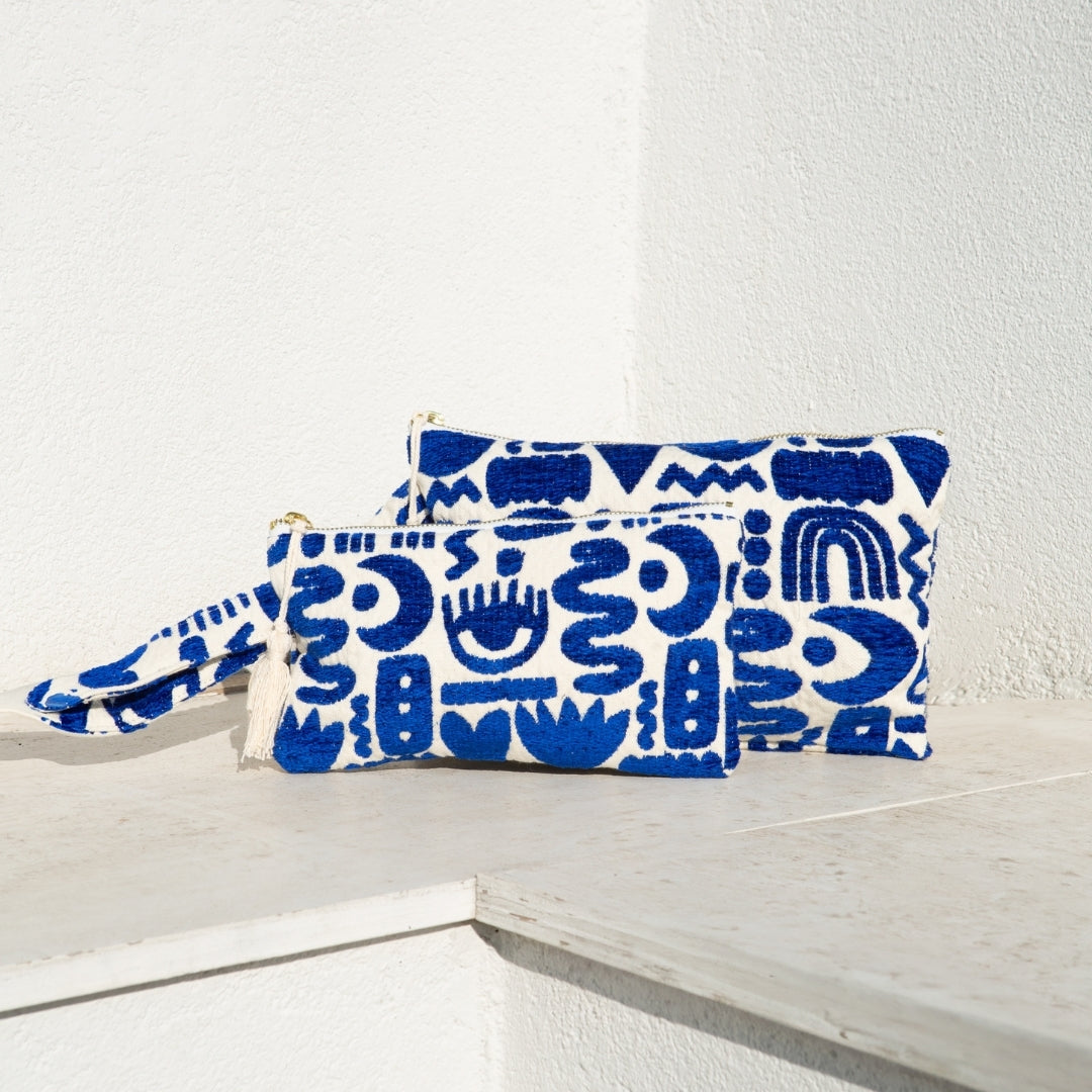 Marabu symbols clutch in deep blue — bold abstract Mediterranean symbols on natural cotton, tassel zip, handmade in Greece
