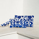 Marabu symbols clutch in deep blue — bold abstract Mediterranean symbols on natural cotton, tassel zip, handmade in Greece