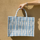 Marabu Unity Square Tote Bag — light blue evil eye and olive branch embroidery on natural cotton canvas, handmade in Greece